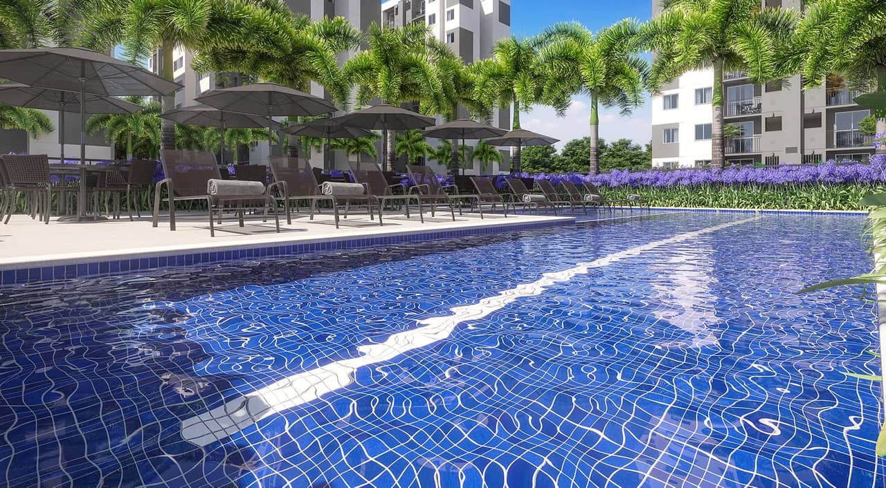 Piscina do Nova Irajá com guarda-sóis, espreguiçadeiras e os blocos ao fundo